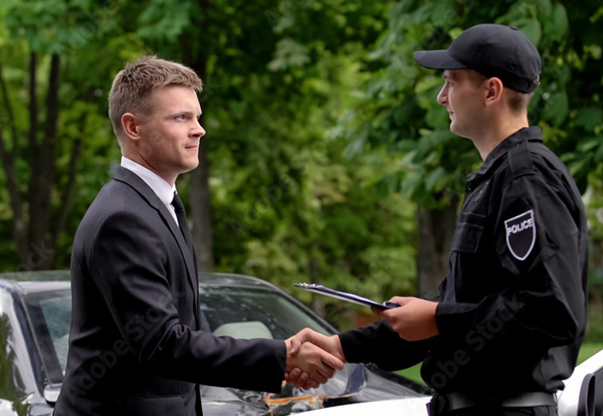 Police officer shaking another man's hand